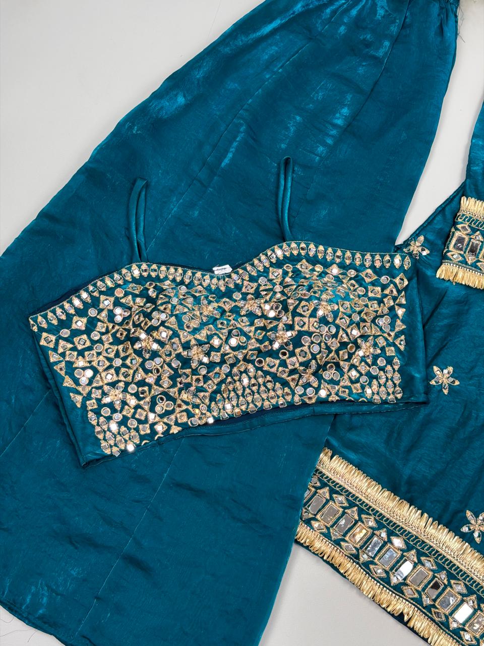 Teal traditional outfit with gold embroidery on a white background